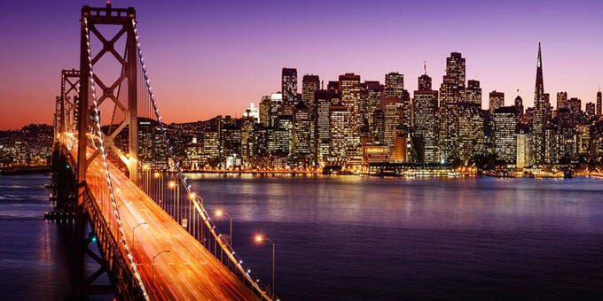 a bridge over water with a city in the background