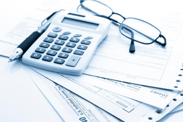 a calculator and glasses on top of a piece of paper