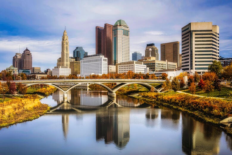 a bridge over a river with a city in the background