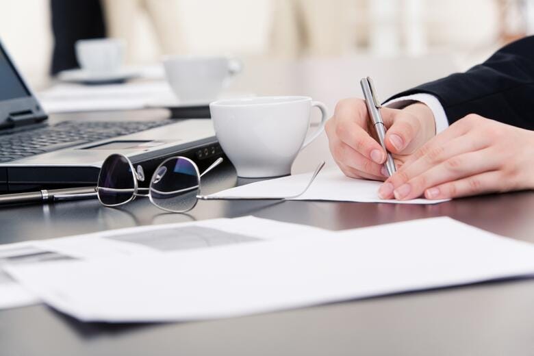 a person writing on a piece of paper