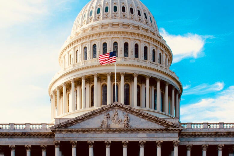 a large white building with a flag on top with El Capitolio in the background