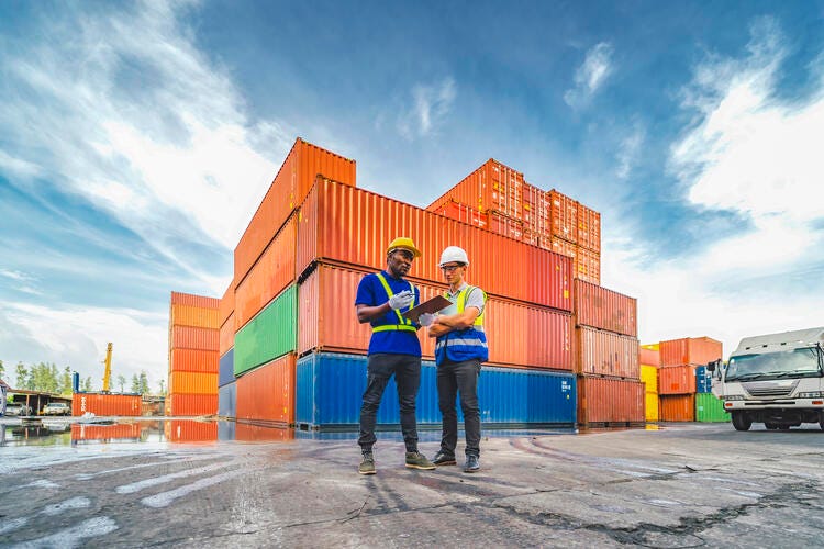 a couple of men in front of a building with a large fire