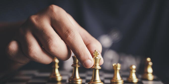 a hand playing chess