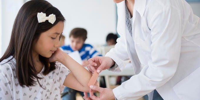 a doctor showing a young girl something on the tablet