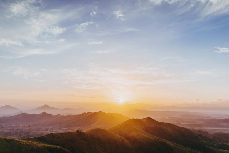 a landscape with hills and a sunset