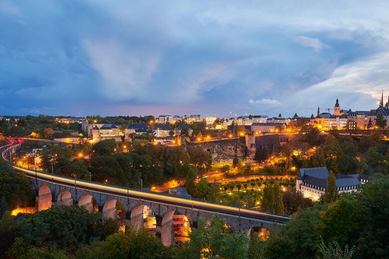 a bridge over a river with a city in the background