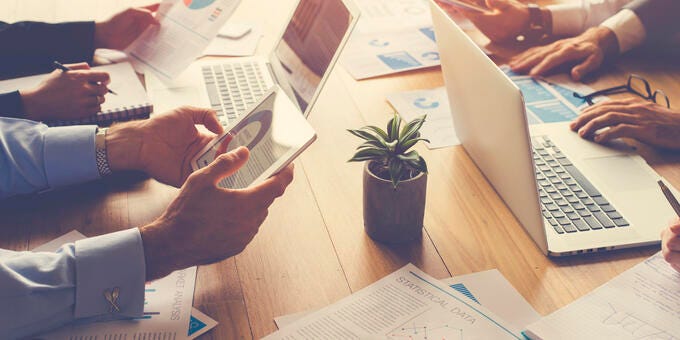 a group of people working on laptops